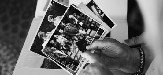 a person holding black and white photos 