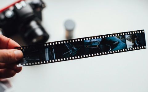 a person holding a negative wondering how to clean negative film