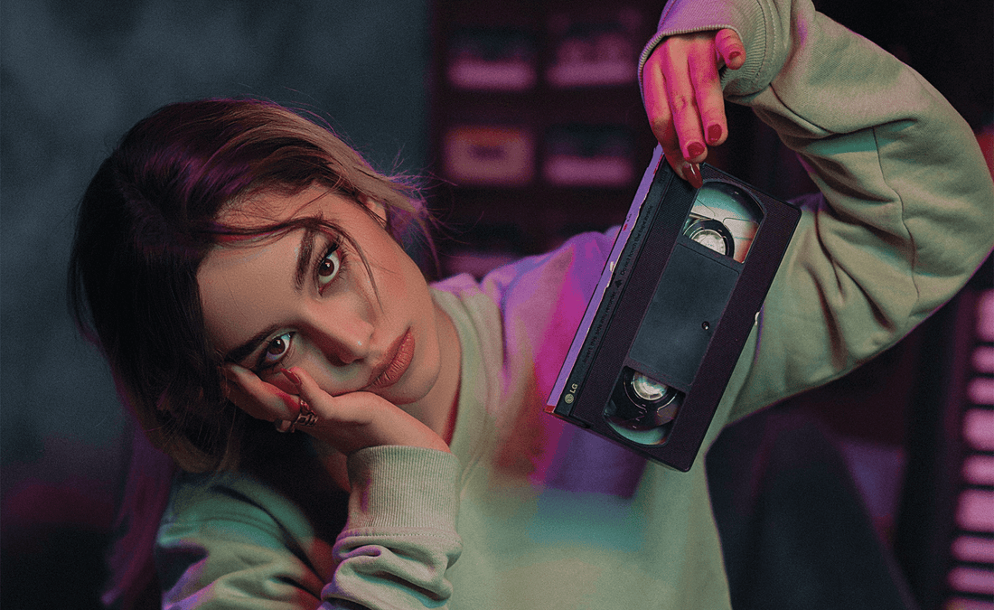 a woman holding an s vhs tape 