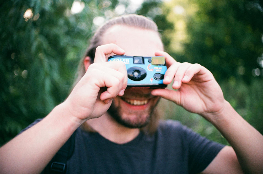 a man holding a Paper Shoot Camera