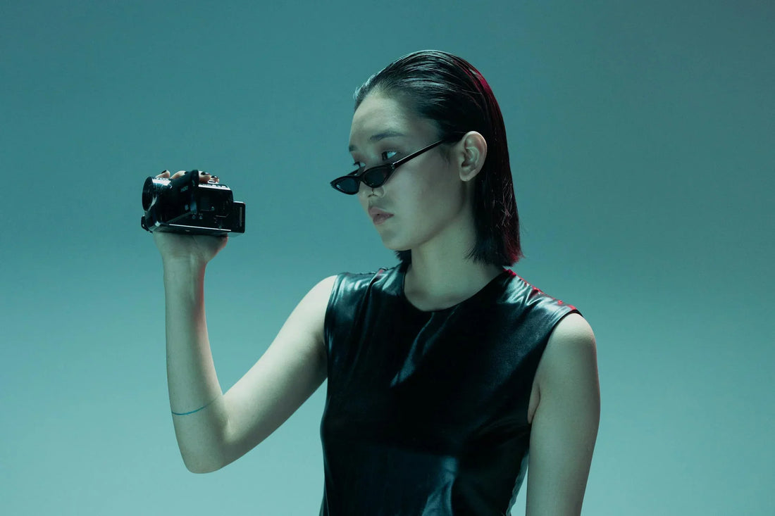 a woman holding a 90s camcorder 