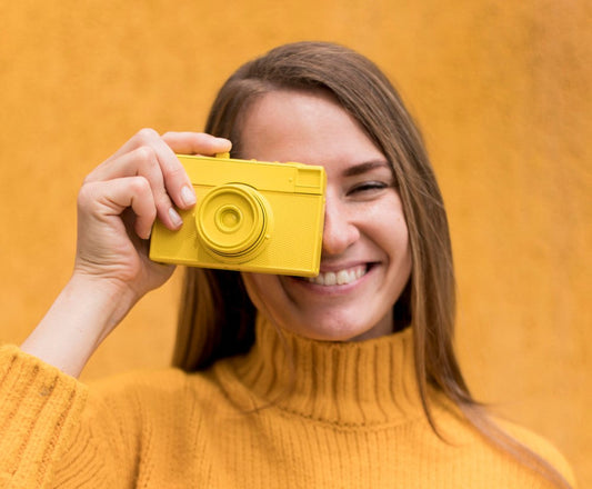 a zoman holding a camera wondering how disposable cameras work